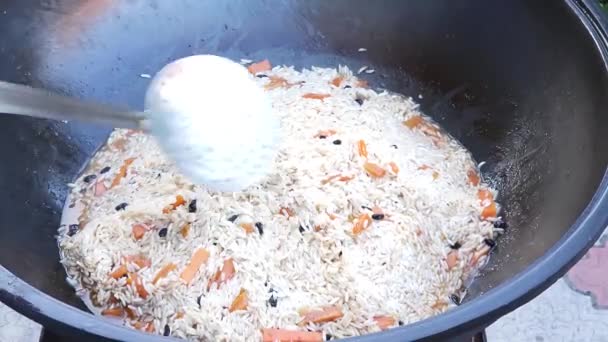 做饭乌兹别克皮拉夫 我们形成了一座座稻山 上盖着一个碗 用铁锅在烤架上蒸腾 — 图库视频影像