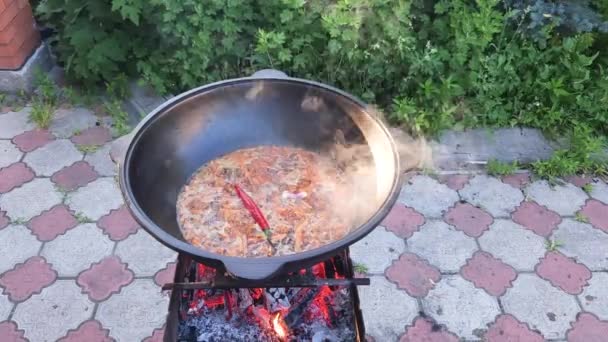 做饭乌兹别克皮拉夫 在烤架上的铸铁大锅中沸腾的锆石 — 图库视频影像