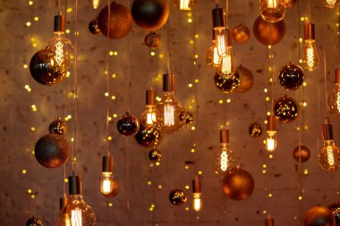Yılbaşı arkaplanı, tuğla duvarda altın topları olan parıldayan LED lambalardan yapılmıştır.