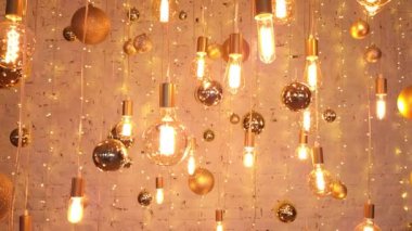 Yılbaşı arkaplanı, tuğla duvarda altın topları olan parıldayan LED lambalardan yapılmıştır.