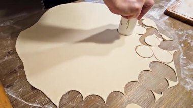 Hamur köftesi yapmak için bir bardakla yuvarlak hamur parçaları sıkıyorum.