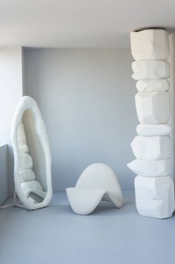 Koltuk, ayna ve pencereli beyaz arka planda doğaçlama sütun