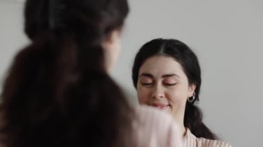 Happy young Caucasian woman standing near mirror holding valentine card. Valentine's Day holiday
