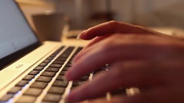 Close up of female hands typing on laptop. Side view. Zoom out shot. Concept of online remote work.