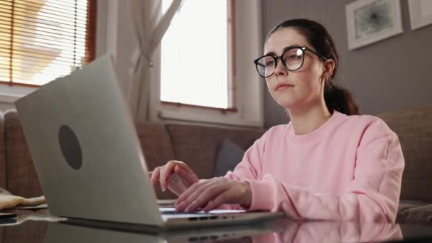 自由职业和远程工作 身边的年轻的高加索美女戴着眼镜坐在笔记本电脑上打字 在总部学习的学生 — 图库视频影像