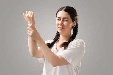 The suffering woman holds her hand. Joint pain, arthrosis and arthritis. The concept of bone diseases and rheumatism.