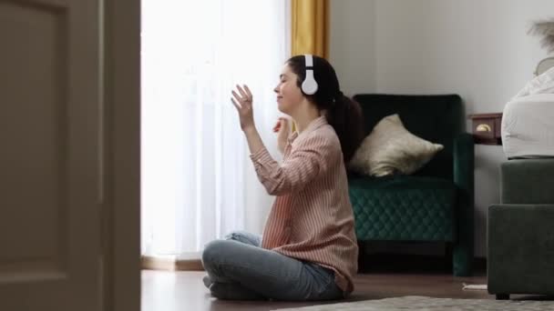 Vista Lateral Mujer Escuchar Música Sentada Piso Ventana Cercana Disfruta — Vídeos de Stock