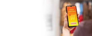 Web banner of drop shipping template. Close up of female hand holding smartphone with online store in screen. Purchase and ordering. Mock up and copy space. Concept of online shopping and consumerism.