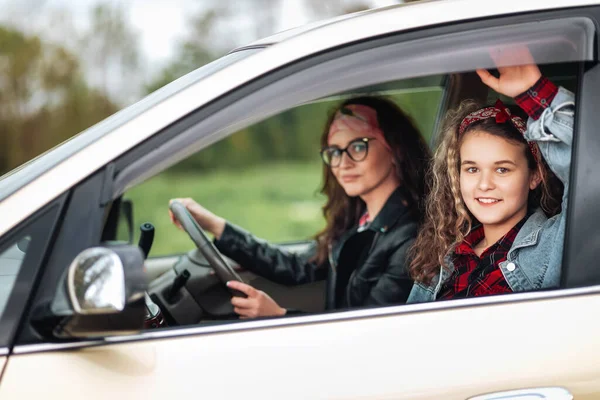Family vacation and trip. Smiling mother and daughter drives in a rented car. The concept of purchase a new automobile.