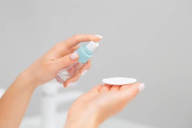 Manikürlü güzel kadın parmakları pamuğa kozmetik sıkar. Uzayı kopyala Cilt bakımı kavramı.