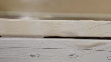 Close up of hand wearing yellow glove clean dirty stove with sponge and detergent. Concept of chores and cleaning service