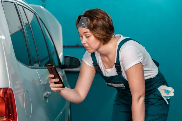 Young Caucasian Woman Mechanic Overall Check Device Scratch Car Concept — Zdjęcie stockowe