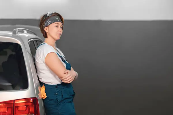 Caucasian Young Woman Blue Coveralls Leaning Car Copy Space Concept — Foto Stock