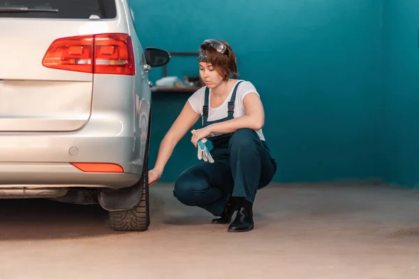 Kobieta Mechanik Sprawdza Oponę Warsztacie Samochodowym Koncepcja Pracy Kobiet Zawodach — Zdjęcie stockowe