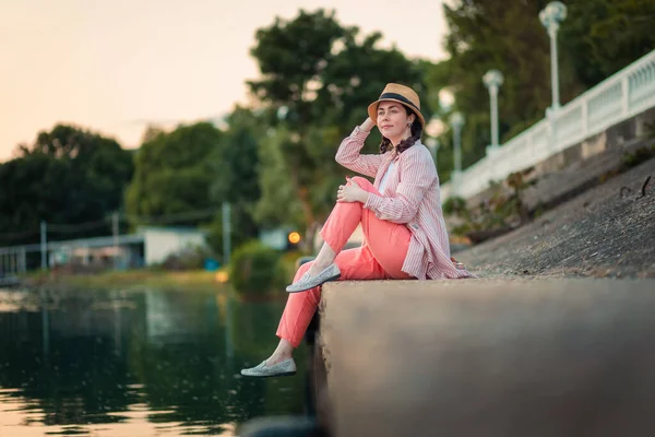 Young Smiling Woman Summer Clothes Straw Hat Sitting River Embankment — Stockfoto