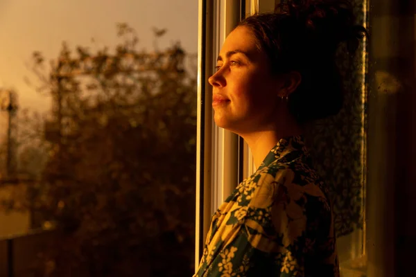 若い笑顔の女性の肖像画は日没時に窓の外を見て夢を見る サイドビュー 心理学と孤独の概念 — ストック写真