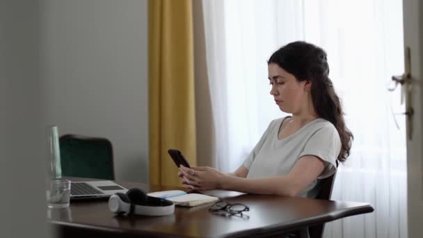 Ofis Işleri Masaüstünde Oturan Beyaz Bir Kadın Akıllı Telefon Kullanıyor — Stok video