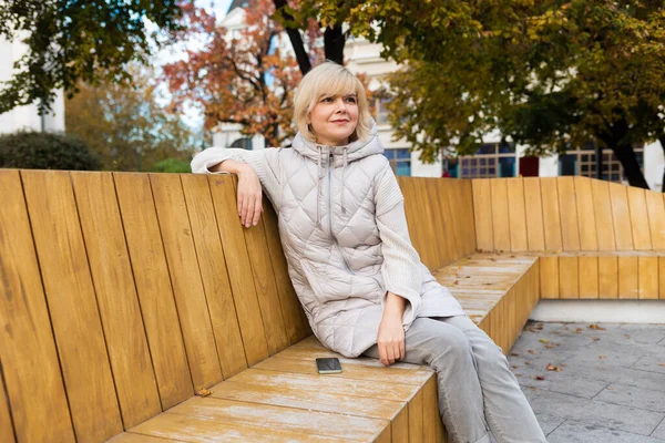 Pretty Caucasian Adult Smiling Blonde Woman Jacket Posing Sitting Bench — ストック写真
