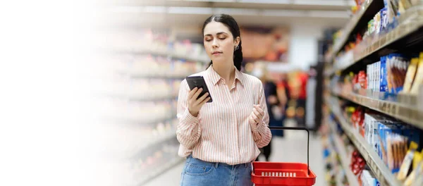 网上购物横幅与模拟了起来 年轻的白人女人用智能手机 手里拿着篮子 超级市场销售应用的概念 — 图库照片