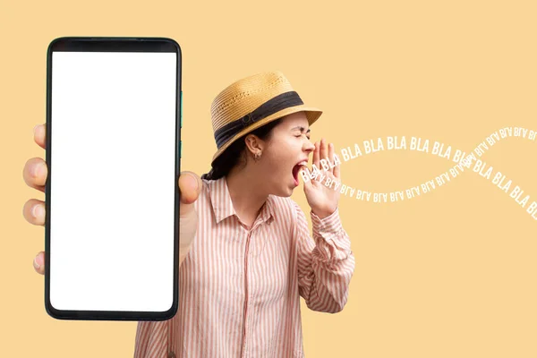 Advertising and smartphone apps. A young Caucasian woman in a straw hat shows a close-up of a phone with a white screen and shouts to someone. Mock up. The concept of online reviews, feedback and shopping.