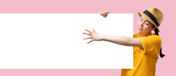 数字广告的网页横幅 一个戴着草帽的年轻的白人美女拿着一个大广告牌 手里拿着一个假广告牌 被粉红色的背景隔离了复制空间 网上购物的概念 — 图库照片