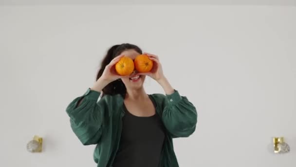 Szczęśliwa Młoda Biała Kobieta Zabawnie Tańczy Łóżku Trzyma Dwa Pomarańcze — Wideo stockowe