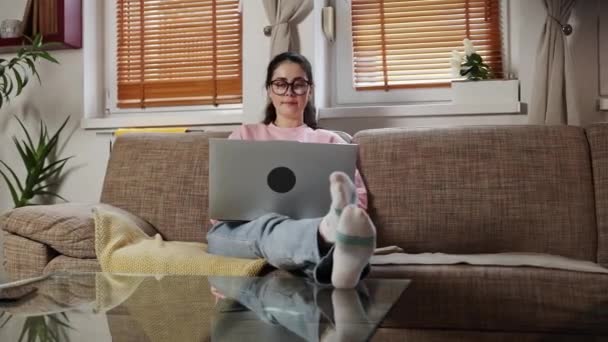 Домашний Офис Улыбающаяся Молодая Белая Женщина Очках Работающая Ноутбуком Сидя — стоковое видео