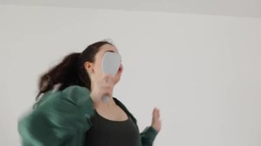 Online kumarhanede kazanmak. Kafkasyalı mutlu genç kadının portresi akıllı telefon tutuyor, kazanmanın ve yatakta dans etmenin tadını çıkarıyor. Uzaklaş. Özgürlük kavramı.