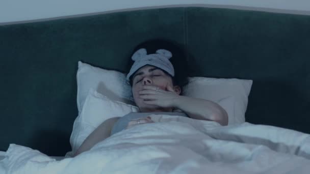 Zmęczona Młoda Kaukaska Kobieta Masce Sypialnej Leży Wygodnym Łóżku Wygląda — Wideo stockowe