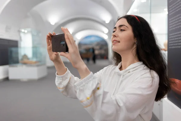ミュージアムツアーでスマホを使った若い白人女性の横顔 現代のアプリ教育 — ストック写真