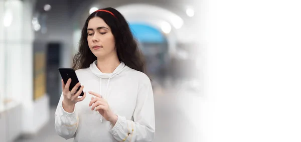 stock image Web banner of digital museum app. Young Caucasian woman using smartphone in her hands. Copy space and mock up. Modern education.