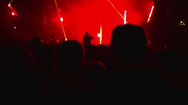 Müzikal rock konserindeki insanlar. Grubun performansını akıllı telefondan kaydeden biri. Kulüp atmosferi, yanıp sönen çok renkli ışık ışınları. Dikiz aynası. Eğlence konsepti.