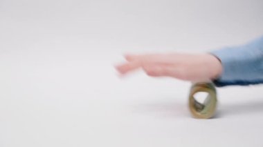 Kadın ve erkek Amerikan dolarlarını yuvarlıyor. Yakın plan. Beyaz arka plan. Yatırım, rüşvet ve borsa kavramı.