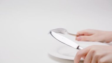 Borsa ve ödeme. Kadının elleri çatal bıçak takımını tutuyor ve yiyecek olarak bir paket para alıyor. El ve paraya yakın çekim. Rüşvet ve maaş kavramı.