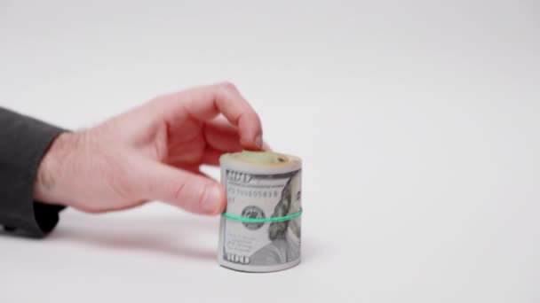 お金を節約 男はロールアップされた米ドル紙幣で貯金箱をカバーしています 白い背景に手と現金のクローズアップ インフレと投資の概念 — ストック動画