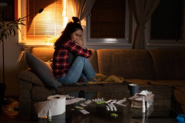 Yalnızlık ve OKB. Kederden muzdarip beyaz bir kadının yan görünüşü kanepede oturup ağlamasıdır. Zihinsel bozukluk ve psikoloji kavramı.