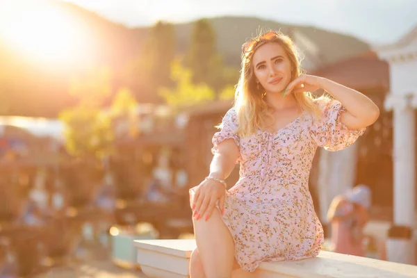 ドレス姿の金髪が柵の上に腰を下ろしている コピースペース 夏休み — ストック写真