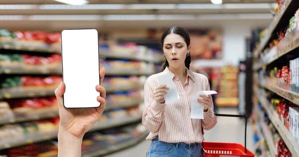 超市的销售 年轻白种人的画像震惊了女人的支票收据 手持显示智能手机与白色屏幕模拟 折扣应用和通货膨胀的概念 — 图库照片