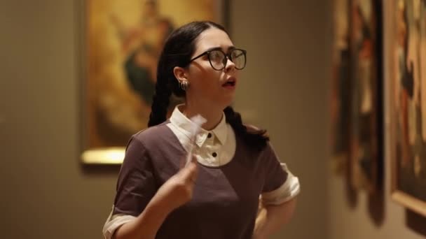 Gözlüklü Güzel Beyaz Kadın Portresi Sanat Eserlerine Bakıyor Kendini Yelpazeliyor — Stok video