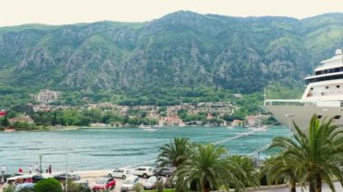 Yaz gezisi. Yeşil dağların panoramik manzarası, Kotor Körfezi ve büyük lüks yolcu gemisi. Sağa çekiyoruz. Karadağ 'da Seyahat.