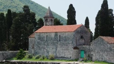 Sürüngenler arasında manastır ya da kilise olan sudan küçük adaya bak. Dini ortaçağ binası