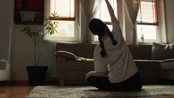 Spor Kıyafetler Giyen Genç Bir Kadın Oturma Odasında Yerde Oturarak — Stok video