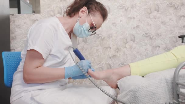 Педиатр Медицинской Маске Перчатках Подающий Ногти Ногах Помощью Электрического Устройства — стоковое видео