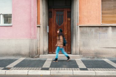 Sokakta yürüyen yalnız bir yayanın yan görüntüsü. Görüntü hareket halinde. Kentsel yaşam kavramı.