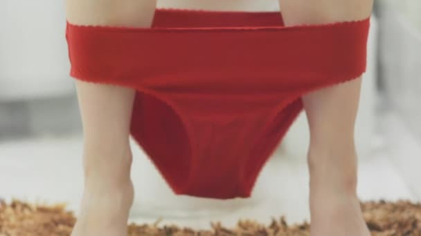 女性は家のトイレに座り 赤い下着から婦人科のタンポンを取ります 足とパンティのクローズアップ 女性の健康 日常衛生 婦人科の概念 — ストック動画