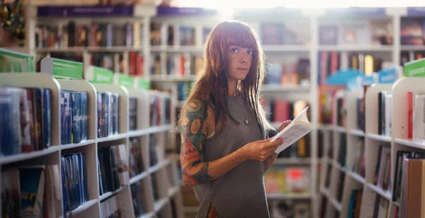 Web banner of shopping books. Side view of Caucasian woman with tattoo holds book in bookstore. Copy space. Concept of education and Book Day.