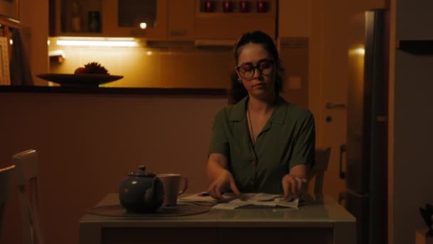 Gözlüklü Üzgün Genç Beyaz Kadın Masada Oturuyor Kağıt Makbuzundaki Harcamaları — Stok video
