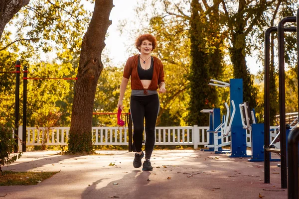 Adult Caucasian pretty woman active training in autumn city park. Healthy lifestyle.