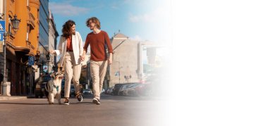 Mutlu şehir hayatının internet afişi. Yolda evcil hayvan gezdiren beyaz bir çift. Mutluluk ailesi. Safkan köpek eğitiyorum..