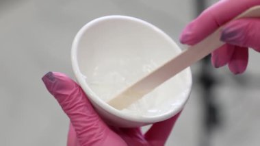 Lazer tüyü almak için spatulayla karıştırılmış ellerinizi kapatın. Kozmetik ve cilt bakımı